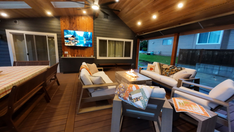 Large arts and crafts backyard ground level deck photo in Seattle with a roof extension