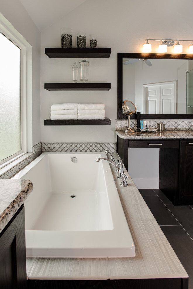 Mid-sized transitional master bathroom in Dallas with shaker cabinets, dark wood cabinets, a corner tub, a corner shower, a one-piece toilet, gray tile, mosaic tile, grey walls, porcelain floors and granite benchtops.