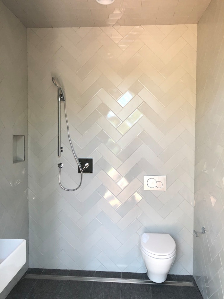This is an example of a small contemporary 3/4 wet room bathroom in Charleston with white cabinets, a wall-mount toilet, yellow tile, ceramic tile, white walls, ceramic floors, a wall-mount sink, grey floor, a niche, a single vanity and a floating vanity.