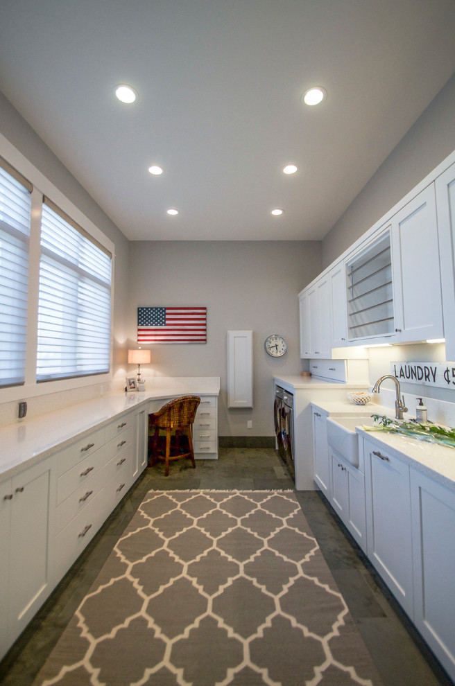 This is an example of a large country galley utility room in Salt Lake City with a farmhouse sink, shaker cabinets, white cabinets, quartzite benchtops, white walls, ceramic floors and a side-by-side washer and dryer.