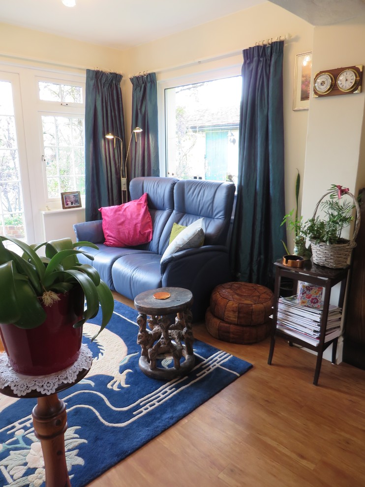 Photo of an eclectic living room with vinyl flooring and a brick fireplace surround.