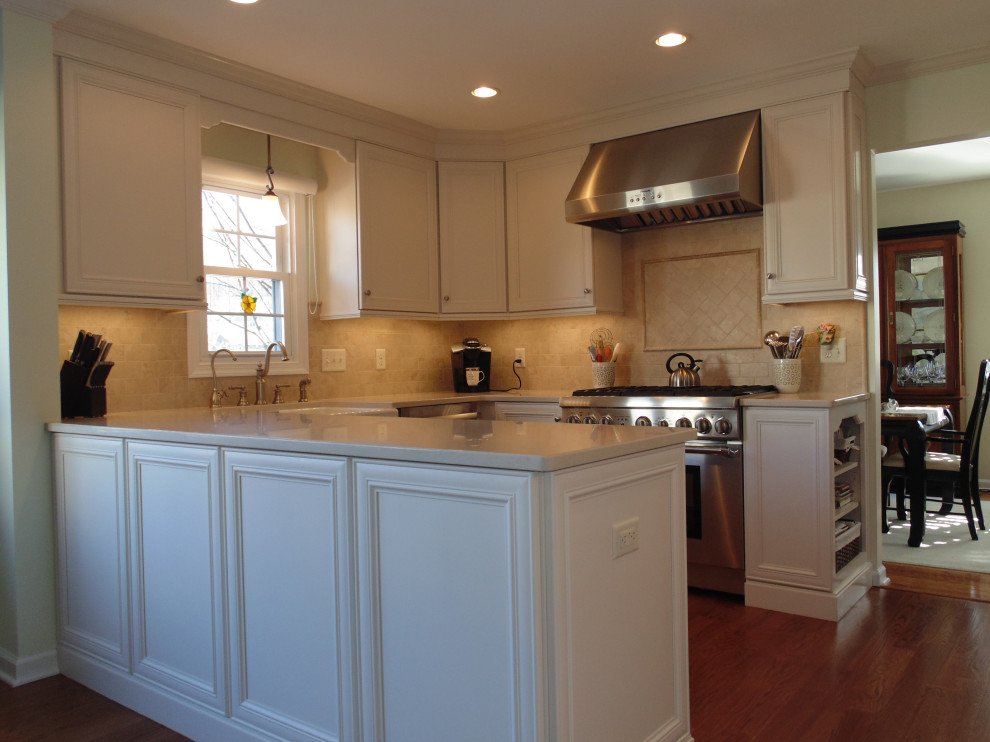 Large transitional u-shaped medium tone wood floor and brown floor eat-in kitchen photo with a farmhouse sink, flat-panel cabinets, white cabinets, quartz countertops, beige backsplash, travertine backsplash, stainless steel appliances and beige countertops