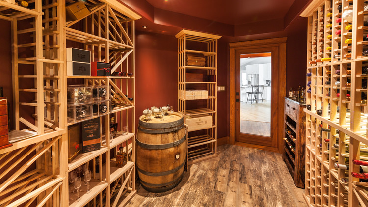 Mid-sized country wine cellar in Other with porcelain floors and display racks.