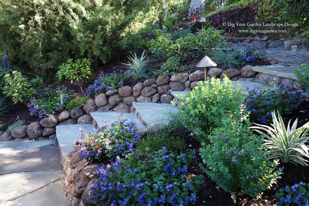 Photo of a mediterranean sloped full sun xeriscape for fall in San Francisco with natural stone pavers.
