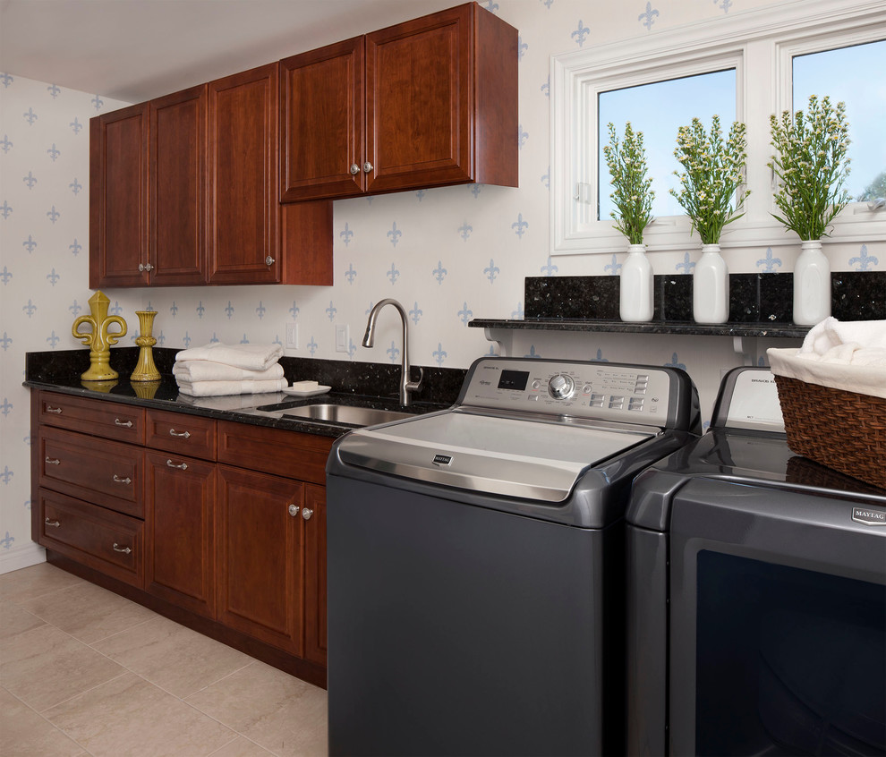 This is an example of a traditional laundry room in Other with an undermount sink, raised-panel cabinets, medium wood cabinets, granite benchtops, white walls and a side-by-side washer and dryer.