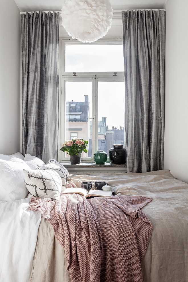This is an example of a large scandinavian master bedroom in Stockholm with white walls.