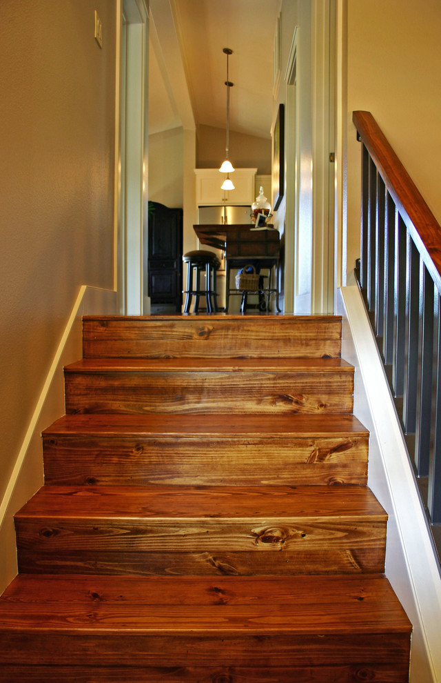 This is an example of a mid-sized beach style wood u-shaped staircase in Austin with wood risers.