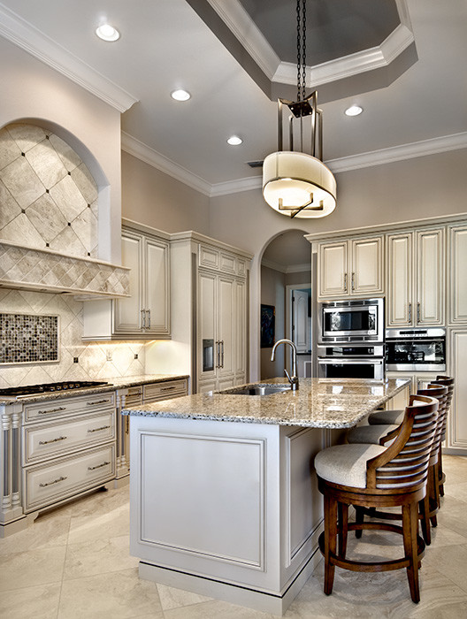 Design ideas for a traditional kitchen in Tampa with an undermount sink, raised-panel cabinets, white cabinets, granite benchtops, multi-coloured splashback, mosaic tile splashback, stainless steel appliances and with island.