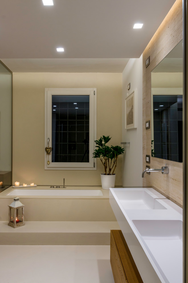 Design ideas for a large contemporary master bathroom in Other with beaded inset cabinets, medium wood cabinets, a drop-in tub, a curbless shower, a two-piece toilet, beige tile, travertine, beige walls, cement tiles, an integrated sink, solid surface benchtops, beige floor and a hinged shower door.