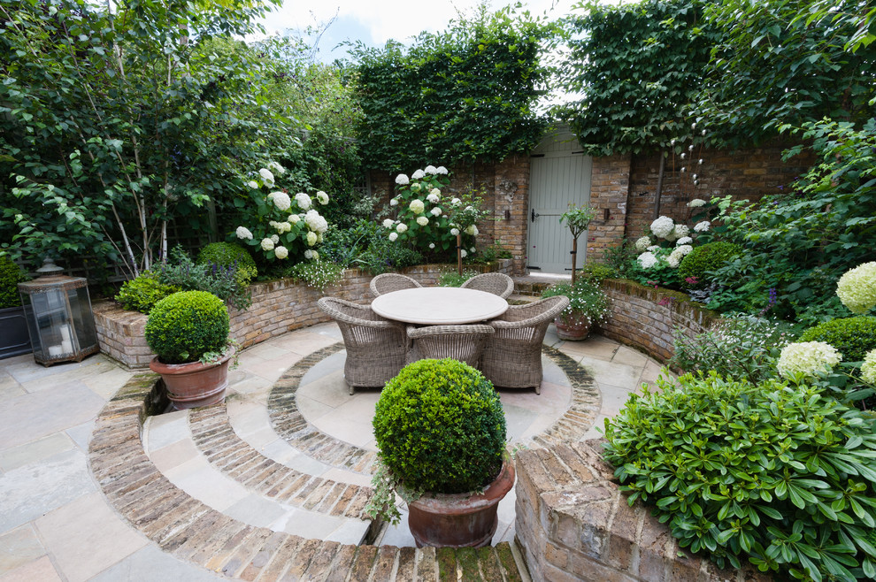 Design ideas for a small traditional patio in London with brick pavers.