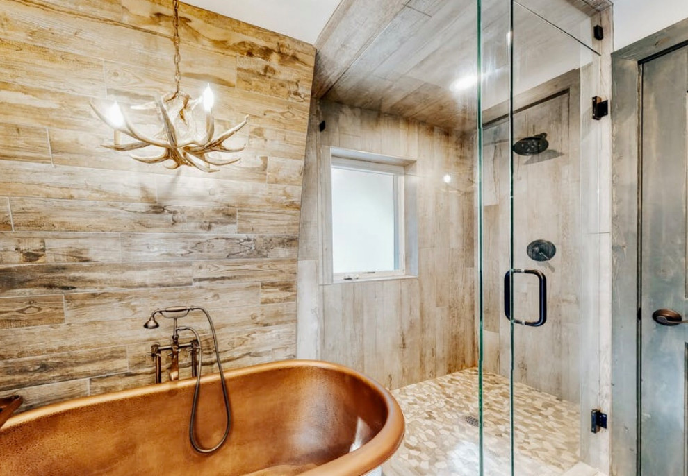 Photo of a medium sized rustic ensuite bathroom with a freestanding bath, a corner shower, grey tiles, ceramic tiles, concrete flooring, grey floors, a hinged door and an enclosed toilet.