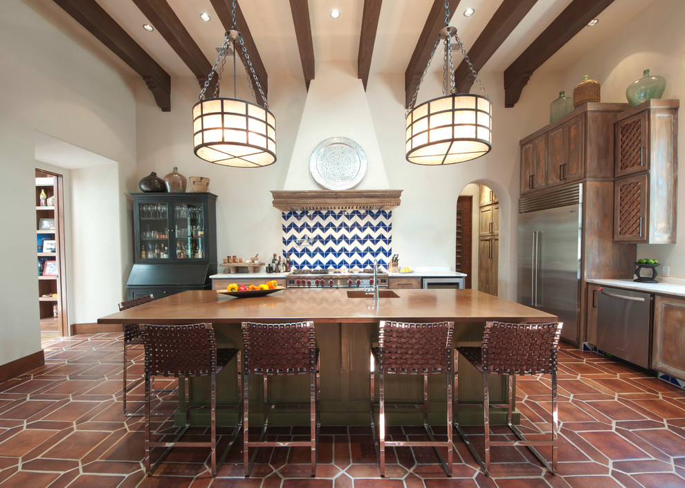 Photo of a mediterranean kitchen in Austin with an integrated sink, distressed cabinets, stainless steel appliances, with island and copper benchtops.