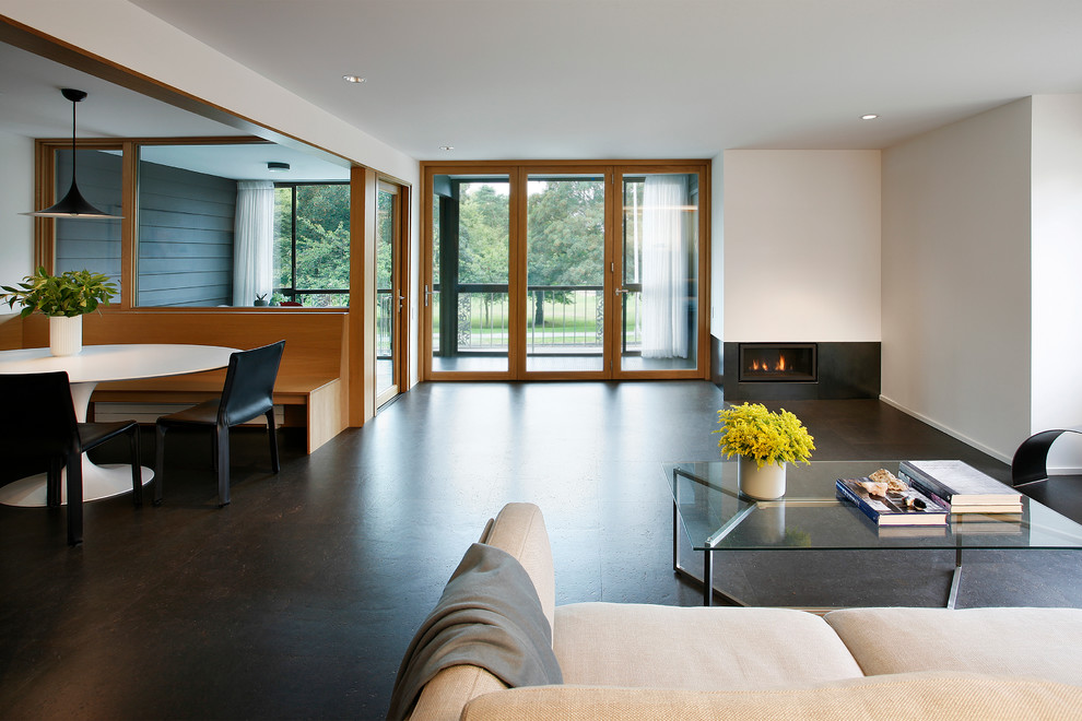 Inspiration for a large midcentury open concept living room in Seattle with white walls, a ribbon fireplace, a metal fireplace surround, no tv and cork floors.