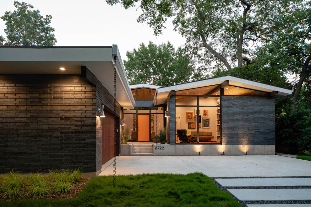 Design ideas for a small midcentury one-storey brick black house exterior in Dallas with a gable roof and a metal roof.