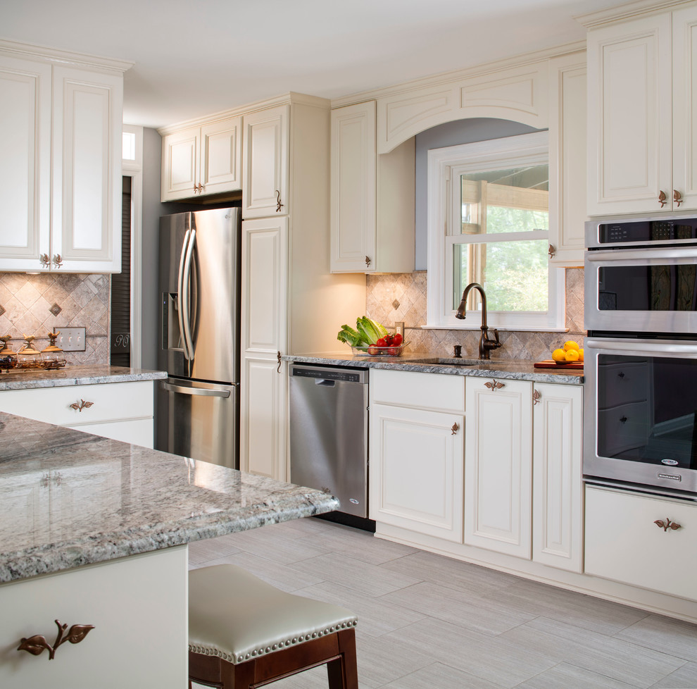 This is an example of a large traditional l-shaped eat-in kitchen in DC Metro with an undermount sink, raised-panel cabinets, white cabinets, grey splashback, stainless steel appliances, ceramic floors and with island.