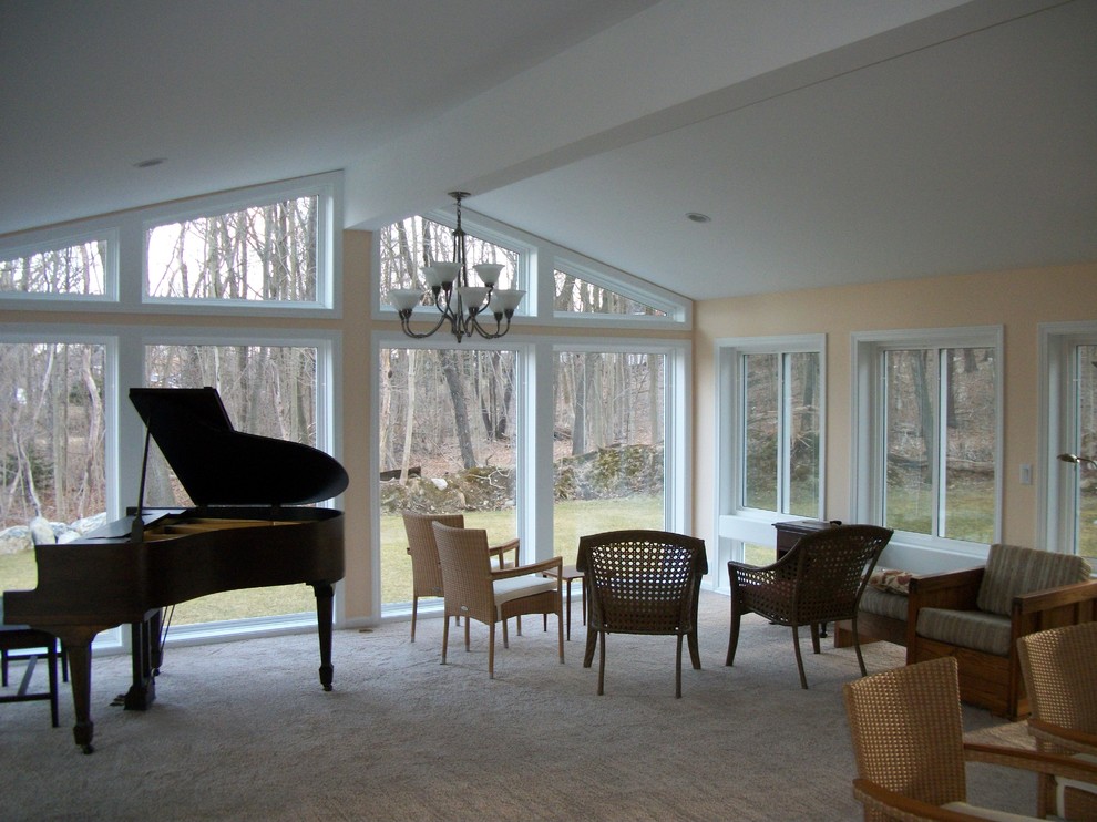 This is an example of a mid-sized traditional sunroom in Manchester with carpet and a standard ceiling.