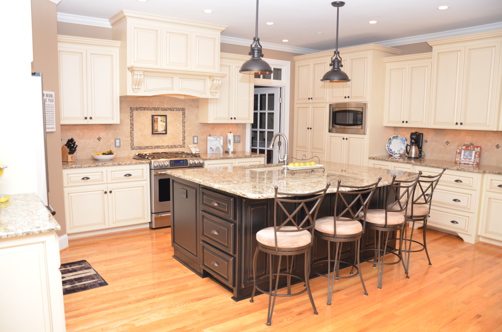 Example of a trendy light wood floor kitchen design in Raleigh with granite countertops, mosaic tile backsplash and stainless steel appliances