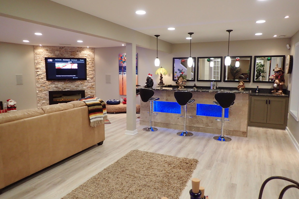 Large eclectic walk-out laminate floor and beige floor basement photo with beige walls, a hanging fireplace and a stone fireplace