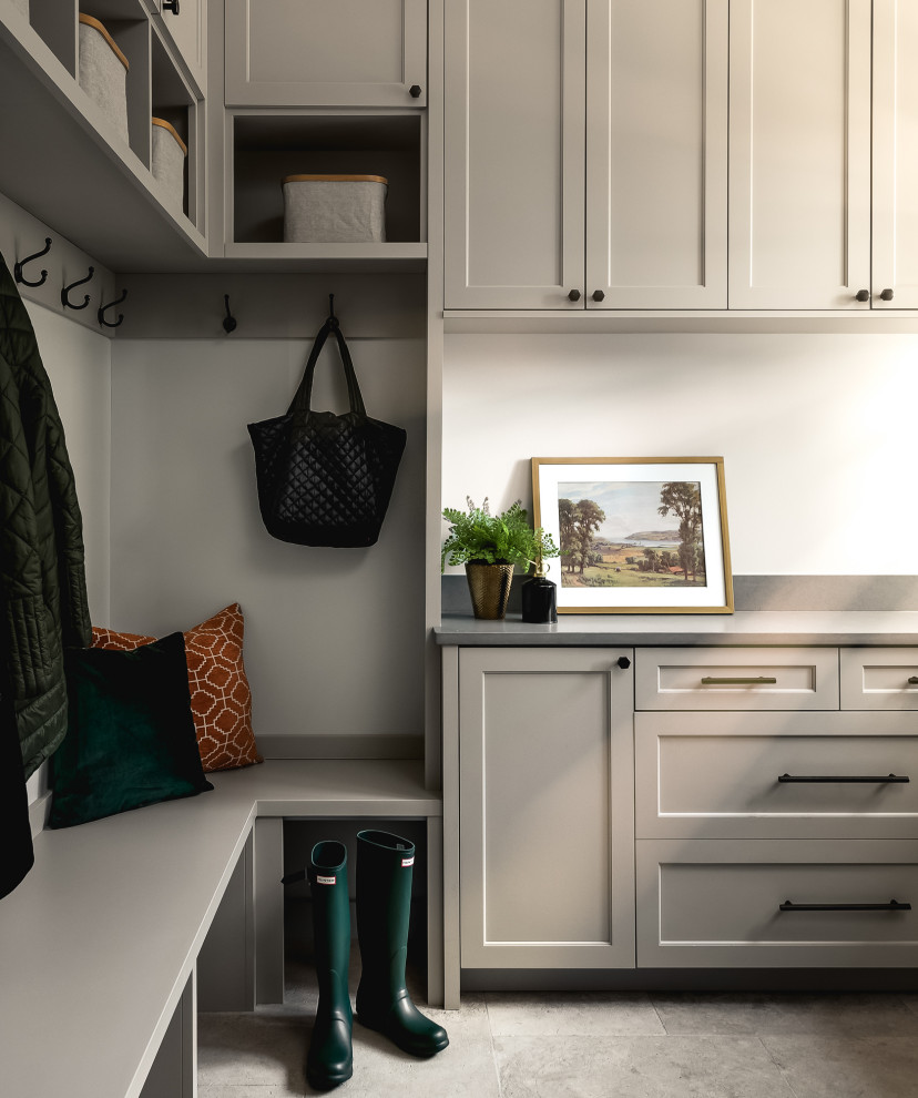 Design ideas for a large transitional u-shaped dedicated laundry room in Chicago with an undermount sink, flat-panel cabinets, beige cabinets, granite benchtops, white walls, travertine floors, a stacked washer and dryer, grey floor and grey benchtop.