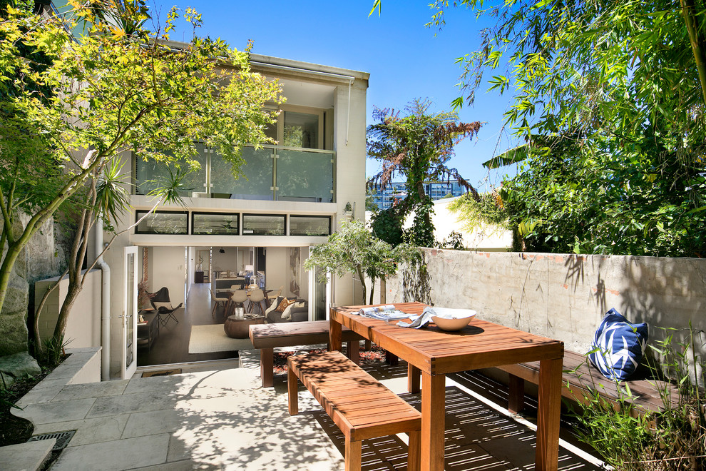 This is an example of a contemporary courtyard patio in Sydney with no cover and tile.