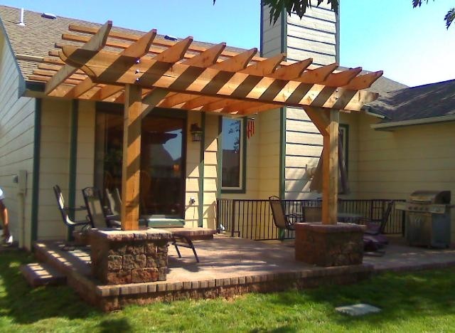 This is an example of a transitional backyard patio in Wichita with concrete pavers and a pergola.