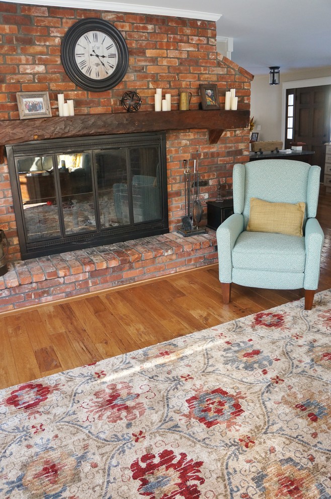 This is an example of a mid-sized traditional open concept living room in Boston with grey walls, medium hardwood floors, a standard fireplace, a brick fireplace surround and a built-in media wall.