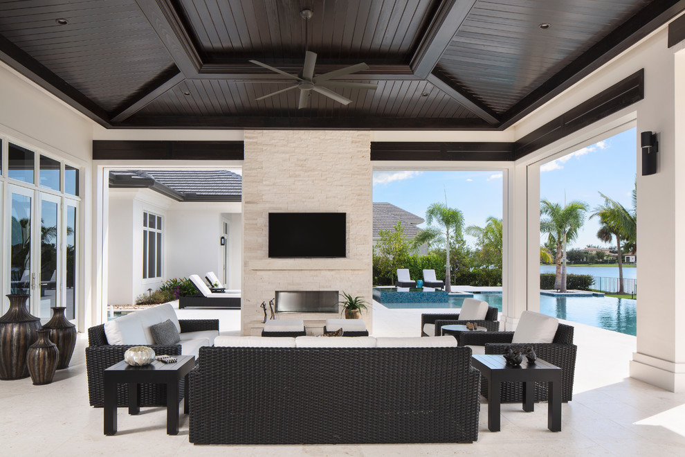 Photo of a large contemporary backyard patio in Miami with a roof extension.