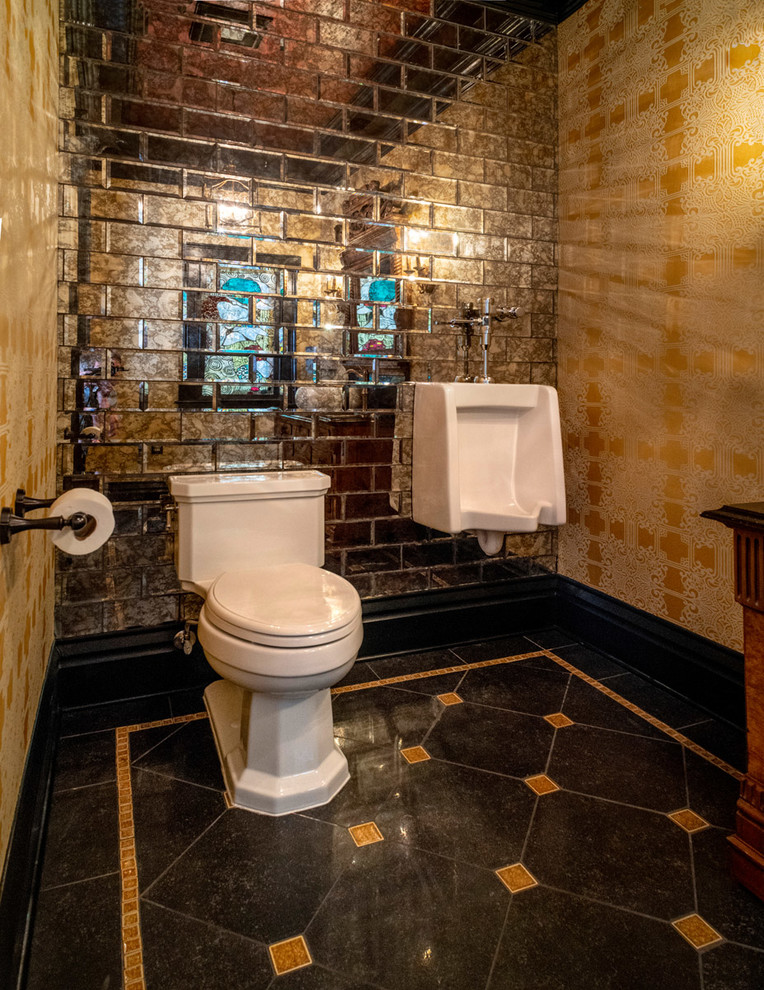 Traditional powder room in Other with furniture-like cabinets, light wood cabinets, a two-piece toilet, mirror tile, yellow walls, porcelain floors, a vessel sink, marble benchtops, grey floor and black benchtops.