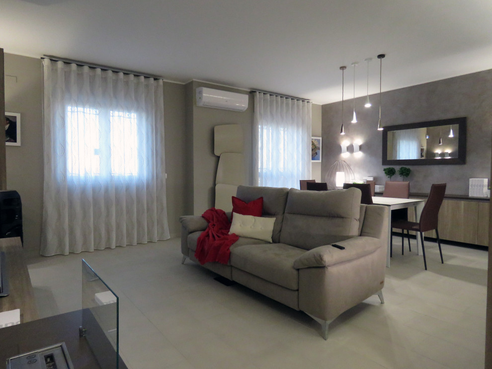 This is an example of a mid-sized contemporary formal open concept living room in Catania-Palermo with multi-coloured walls, porcelain floors, a two-sided fireplace, a tile fireplace surround, a freestanding tv and beige floor.