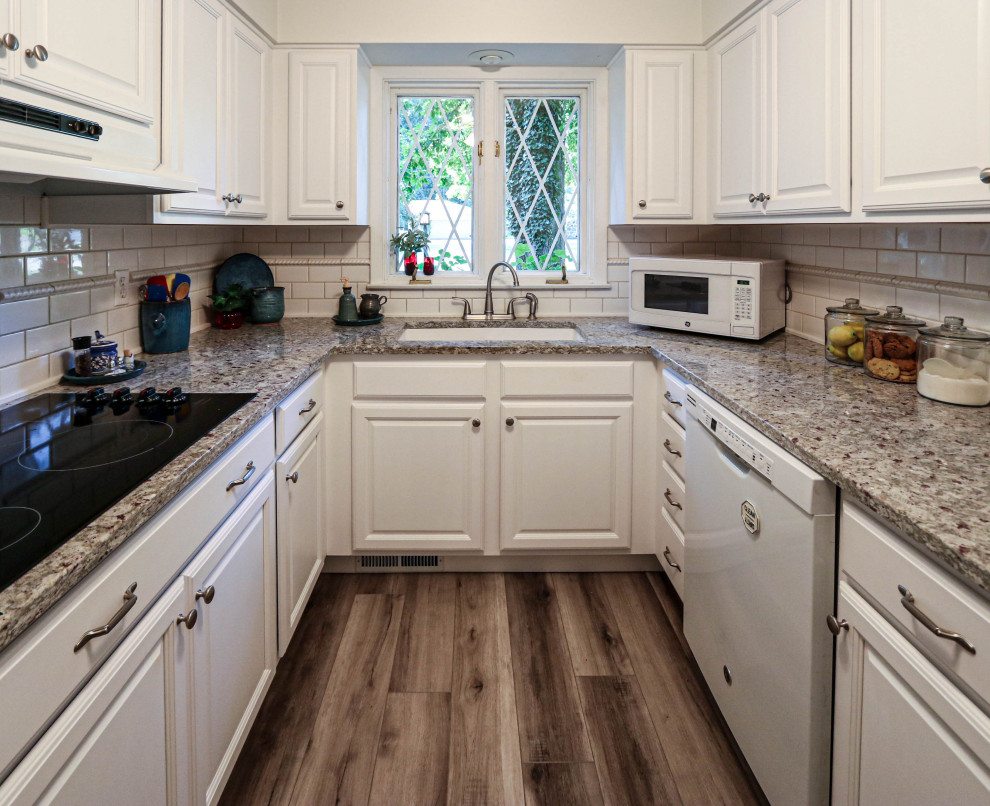Photo of a small traditional u-shaped kitchen pantry in Cleveland with a submerged sink, raised-panel cabinets, white cabinets, granite worktops, vinyl flooring, no island, brown floors and beige worktops.
