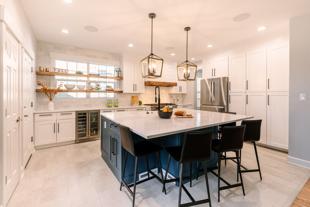 Design ideas for a large country l-shaped open plan kitchen in Denver with a single-bowl sink, shaker cabinets, blue cabinets, quartzite benchtops, white splashback, ceramic splashback, stainless steel appliances, vinyl floors, with island, beige floor and white benchtop.