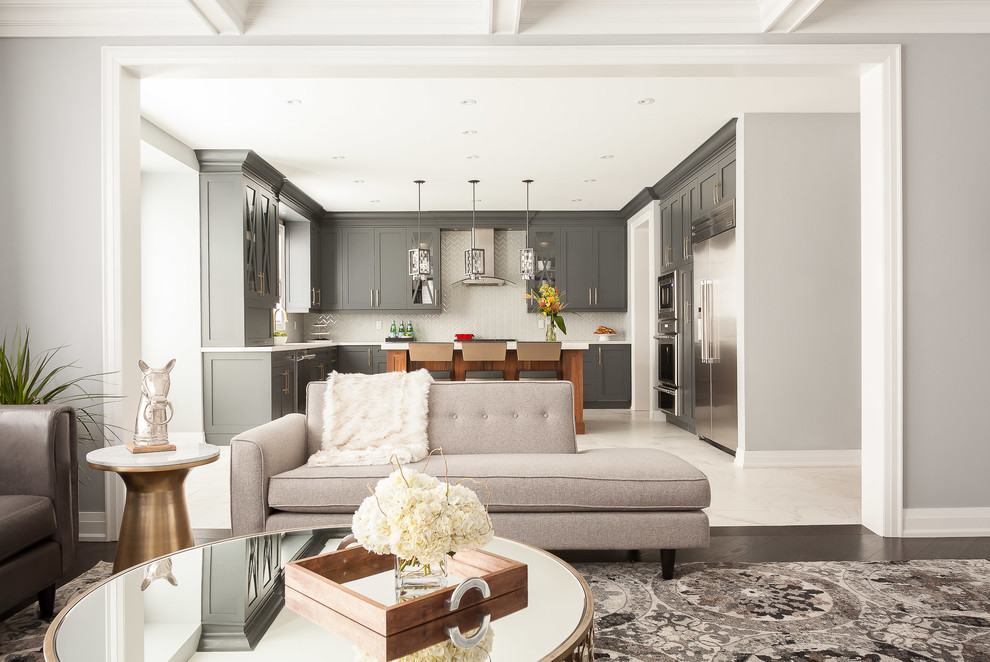 Photo of a mid-sized transitional open concept living room in Toronto with porcelain floors, grey walls, a standard fireplace, a plaster fireplace surround and a concealed tv.