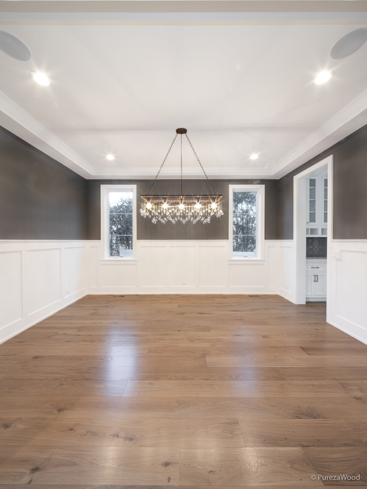 This is an example of a mid-sized traditional kitchen/dining combo in Chicago with brown walls, light hardwood floors, brown floor, recessed and decorative wall panelling.