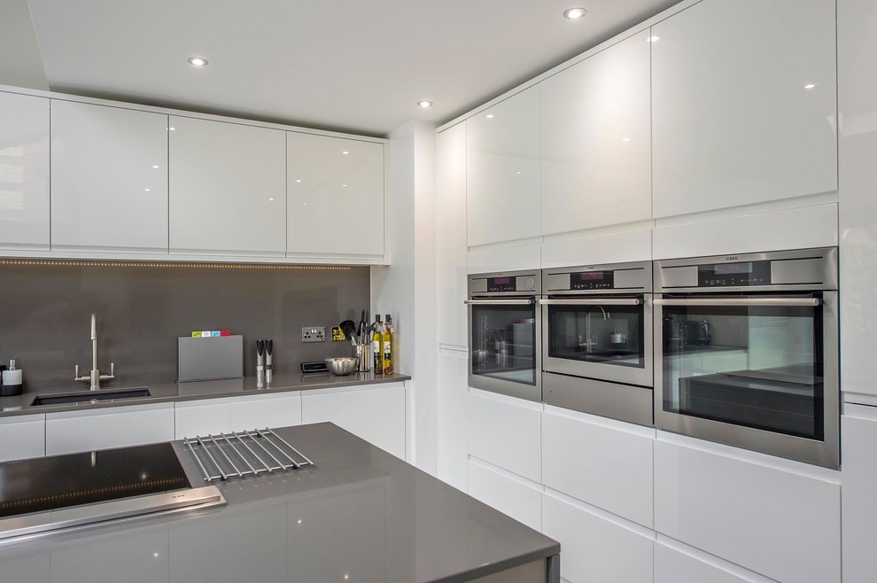 Design ideas for a mid-sized modern l-shaped eat-in kitchen in Other with an undermount sink, flat-panel cabinets, white cabinets, quartzite benchtops, grey splashback, stainless steel appliances, with island and white floor.