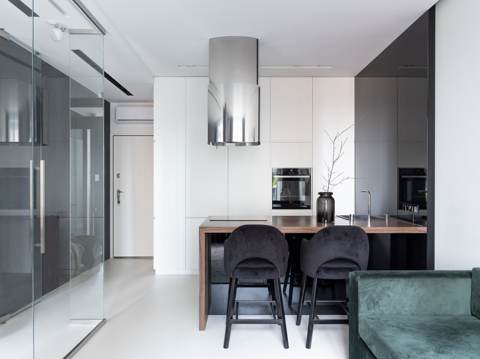 Contemporary u-shaped open plan kitchen in Moscow with a drop-in sink, flat-panel cabinets, black cabinets, black appliances, a peninsula, white floor and brown benchtop.