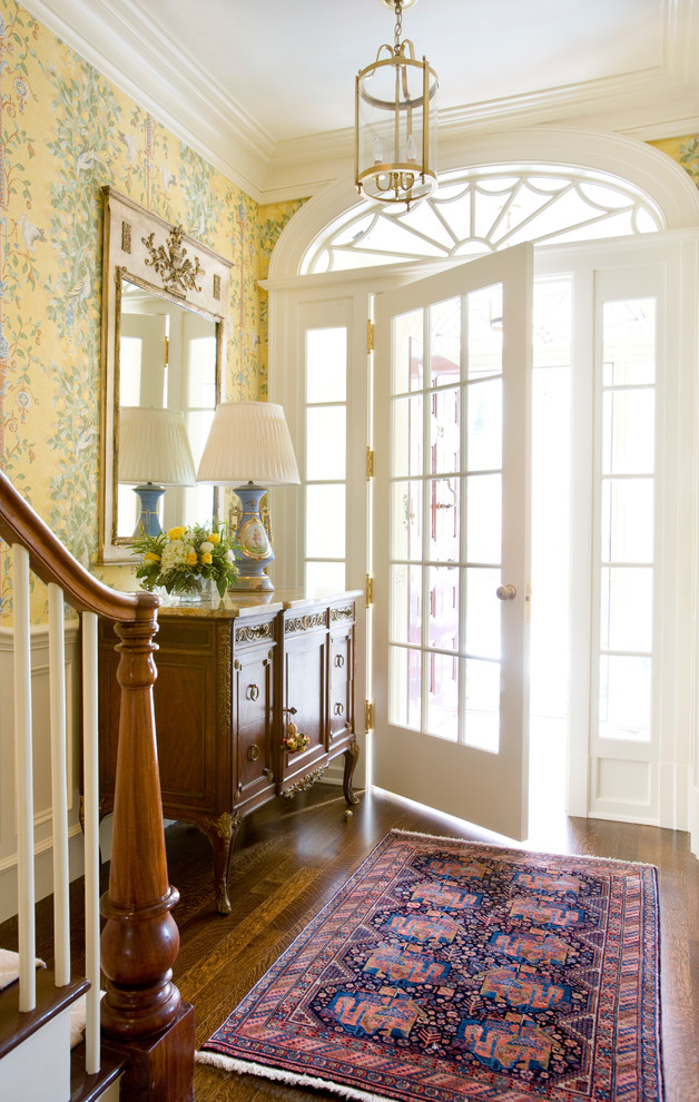 Inspiration for a mid-sized traditional entry hall in Boston with yellow walls, dark hardwood floors, a pivot front door and a white front door.
