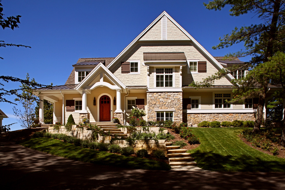Design ideas for a large traditional three-storey beige exterior in Grand Rapids with mixed siding and a gable roof.