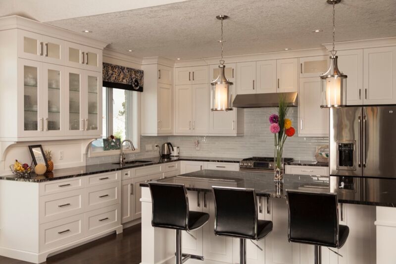Open concept kitchen - large transitional l-shaped dark wood floor open concept kitchen idea in Toronto with an undermount sink, shaker cabinets, white cabinets, marble countertops, blue backsplash, glass tile backsplash, stainless steel appliances and an island