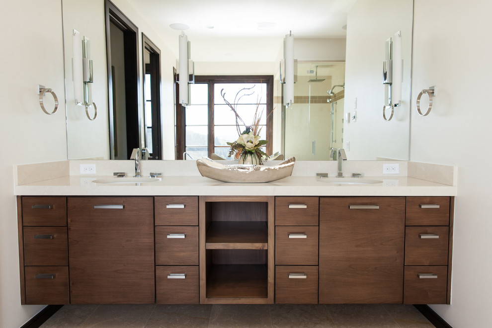 Photo of a mid-sized transitional master bathroom in Salt Lake City with a drop-in sink, flat-panel cabinets, medium wood cabinets, granite benchtops, a drop-in tub, an open shower, a one-piece toilet, brown tile, ceramic tile, white walls, ceramic floors, brown floor and a hinged shower door.