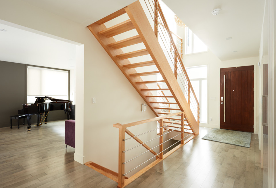 Photo of a modern wood straight staircase in Edmonton with open risers and metal railing.