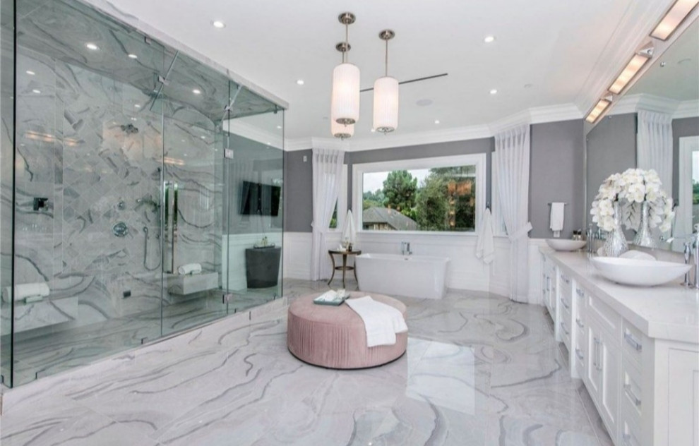 This is an example of a mid-sized contemporary master bathroom in Los Angeles with glass-front cabinets, yellow cabinets, a one-piece toilet, gray tile, grey walls, marble floors, an integrated sink, marble benchtops, multi-coloured floor, a hinged shower door, white benchtops, a niche, a double vanity and a built-in vanity.
