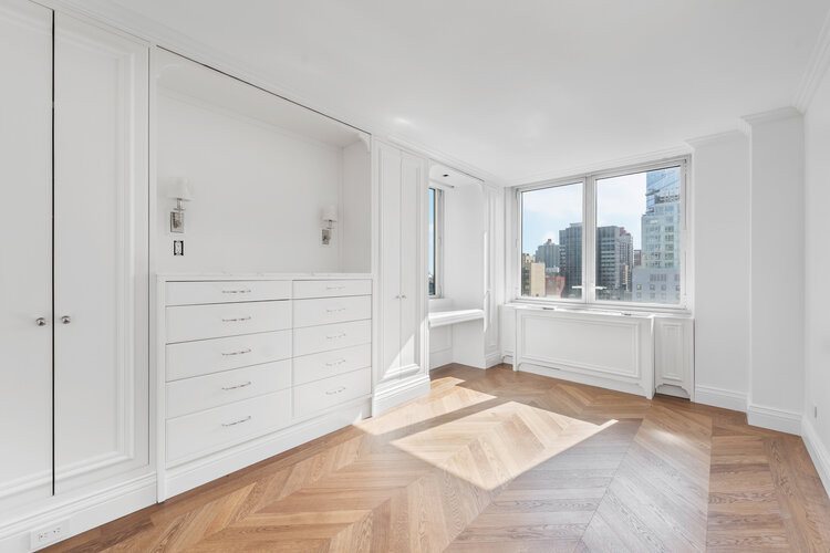 This is an example of a medium sized classic guest bedroom in New York with white walls, light hardwood flooring, no fireplace and beige floors.