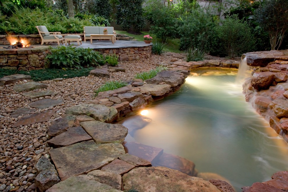 Small eclectic backyard custom-shaped natural pool in Houston with a water feature and natural stone pavers.