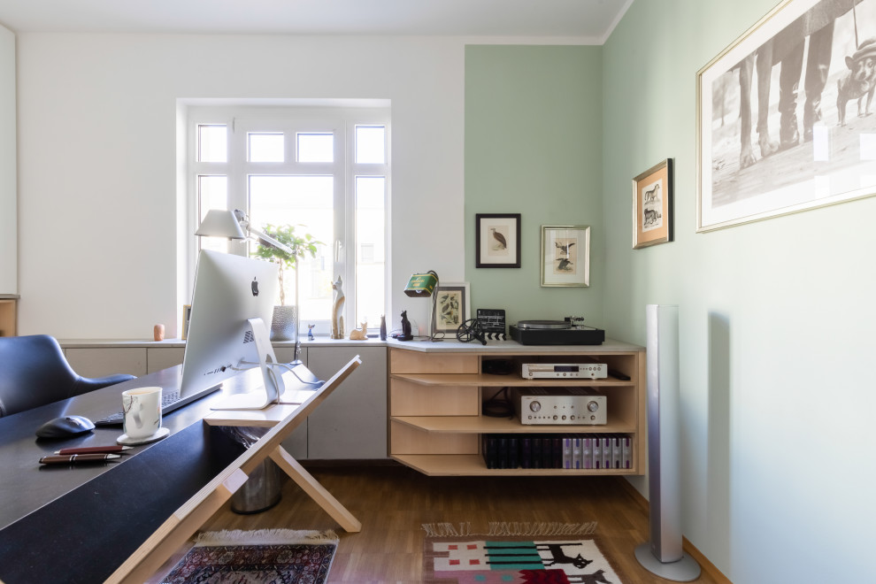 Kleines Modernes Arbeitszimmer mit Arbeitsplatz, weißer Wandfarbe, hellem Holzboden, freistehendem Schreibtisch und braunem Boden in Düsseldorf