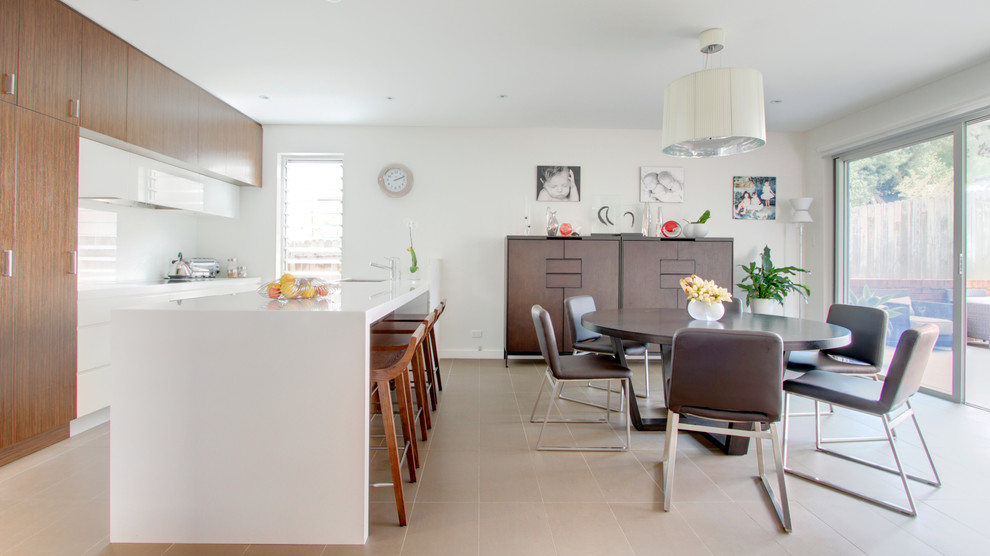 Photo of a contemporary galley eat-in kitchen in Sydney with flat-panel cabinets, white cabinets, white splashback and glass sheet splashback.