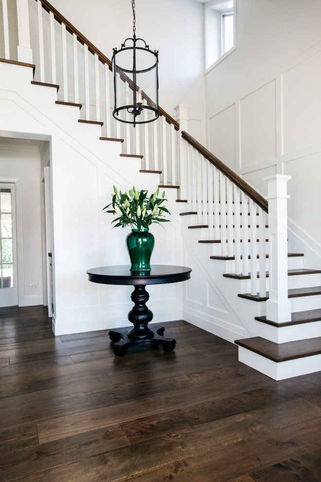 Photo of a mid-sized beach style wood l-shaped staircase in Sydney with wood risers, wood railing and panelled walls.