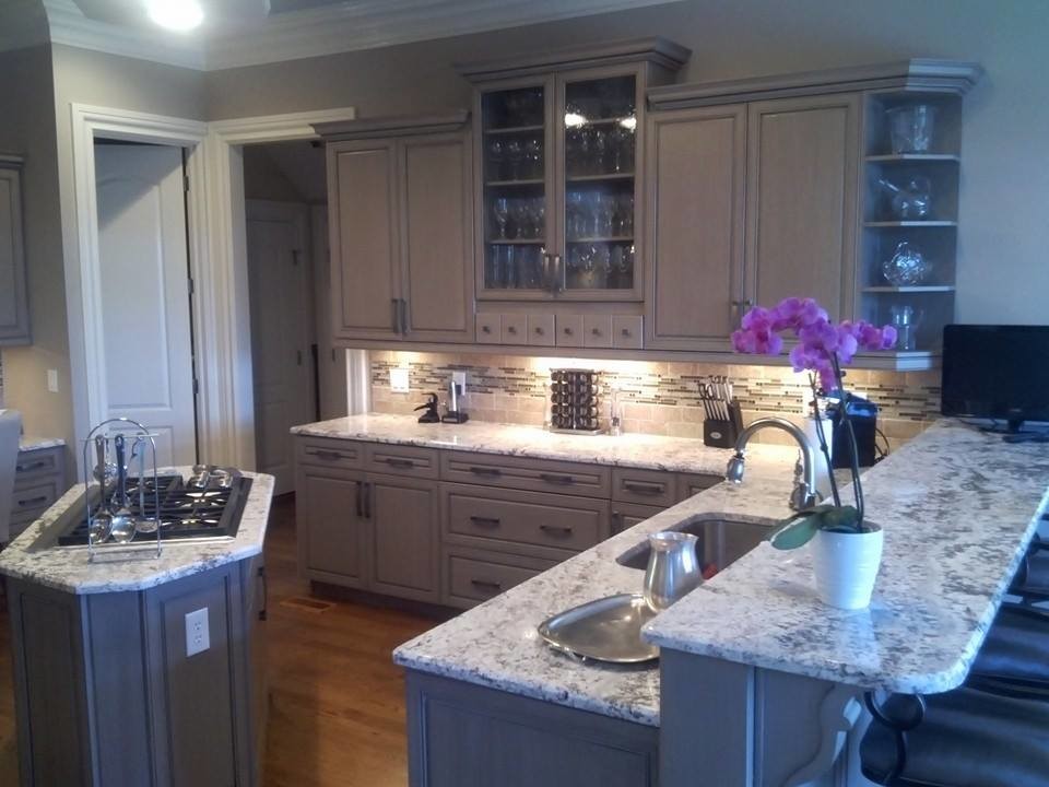 Mid-sized transitional l-shaped eat-in kitchen photo with a single-bowl sink, raised-panel cabinets, gray cabinets, granite countertops, beige backsplash, glass tile backsplash and an island
