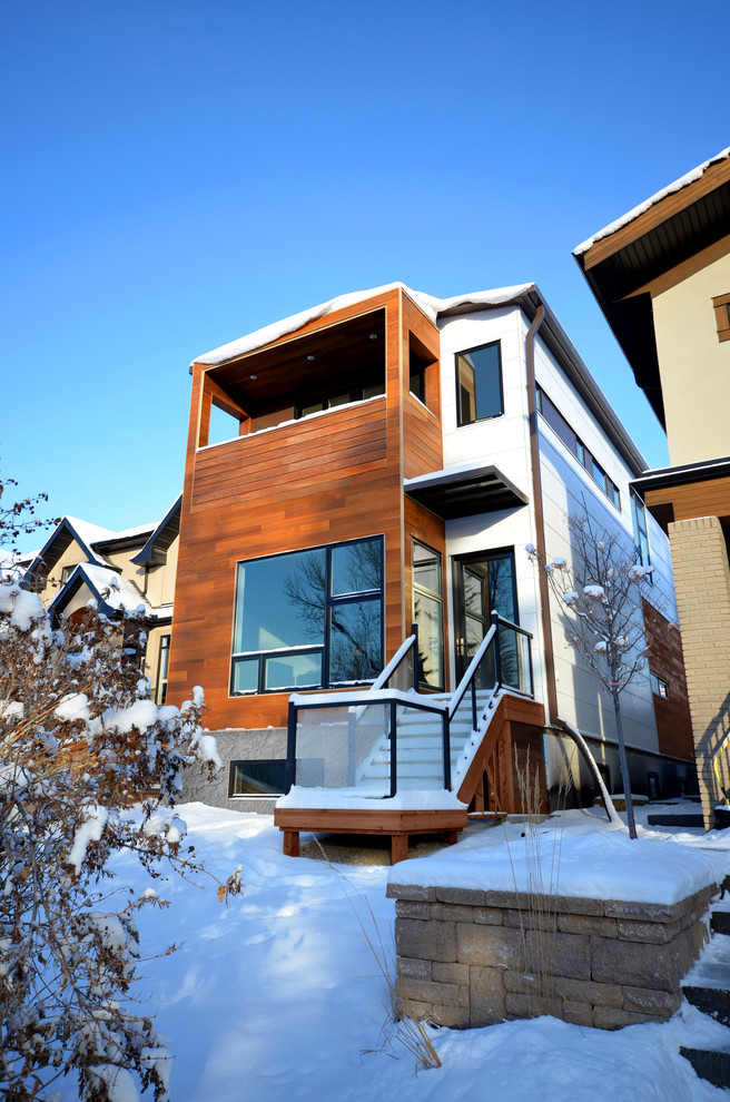 Inspiration for a contemporary two-storey exterior in Calgary with mixed siding.