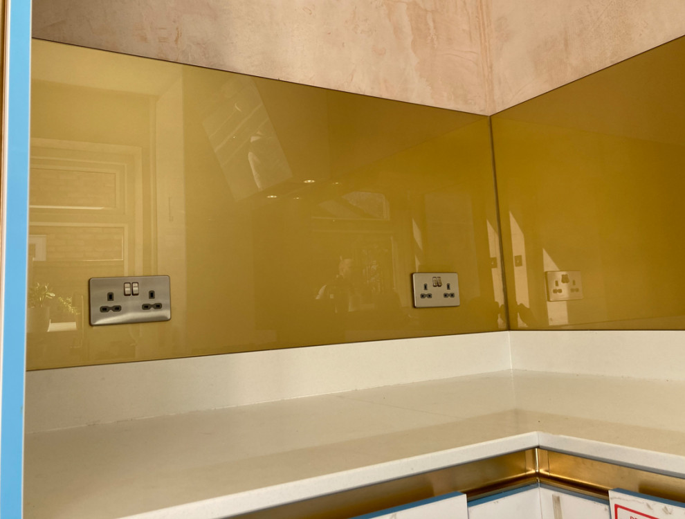 Inspiration for a contemporary kitchen in Manchester with metallic splashback and glass sheet splashback.