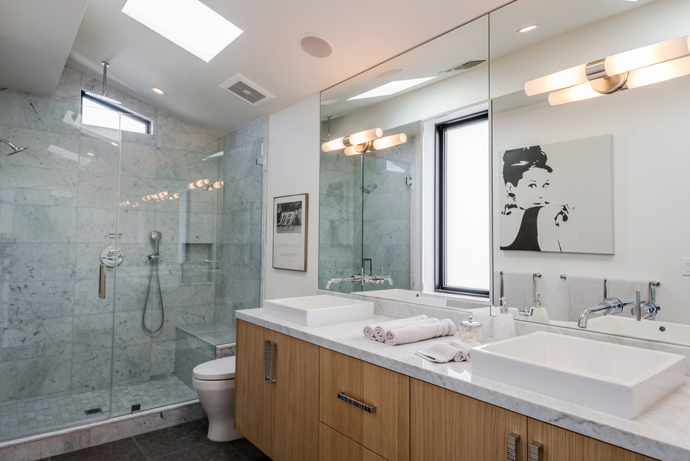 Design ideas for a contemporary bathroom in Los Angeles with flat-panel cabinets, medium wood cabinets, an alcove shower, white tile, white walls, a vessel sink, grey floor, a hinged shower door and white benchtops.